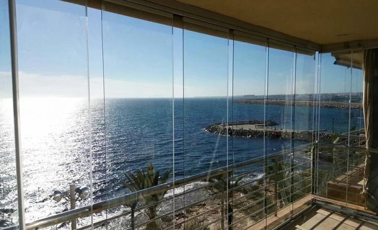 Cortinas de cristal sin perfilería como cierre lateral de pérgola bioclimática en terraza de lujo